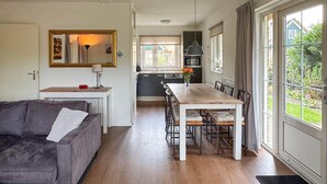 Een moderne keuken met een eethoek, een bank en een groot raam.
