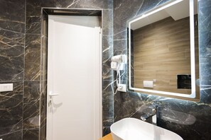 A bathroom with a white sink, a mirror, and a door. - Cozy Apartment 01 in Durr s (Durrës)