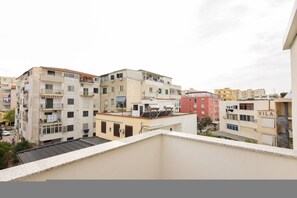 A residential area with multi-story buildings, some with balconies and air conditioning units. - Cozy Apartment 01 in Durr s (Durrës)