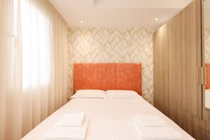 A hotel room with a large bed, a wardrobe, and a mirror. - Cozy Apartment 01 in Durr s (Durrës)
