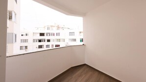 Een balkon met uitzicht op omliggende gebouwen.