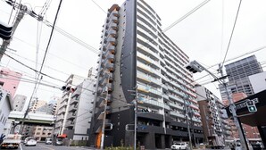 Un immeuble à plusieurs étages doté d’une architecture moderne, avec des balcons et une entrée imposante.