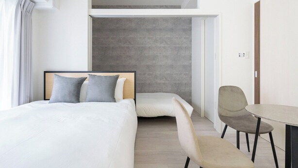 Une chambre d’hôtel moderne, équipée d’un lit, d’un bureau et d’une chaise.