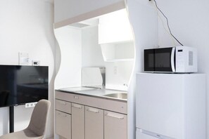 A modern kitchen with a microwave, sink, and cabinets. - SERENITE franc Namba (Osaka)