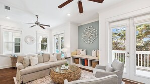 A living room with a sofa, armchair, coffee table, and decorative wall piece.