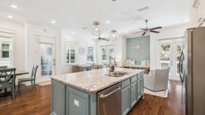 A spacious kitchen with a large island, modern appliances, and a dining area with a table and chairs.
