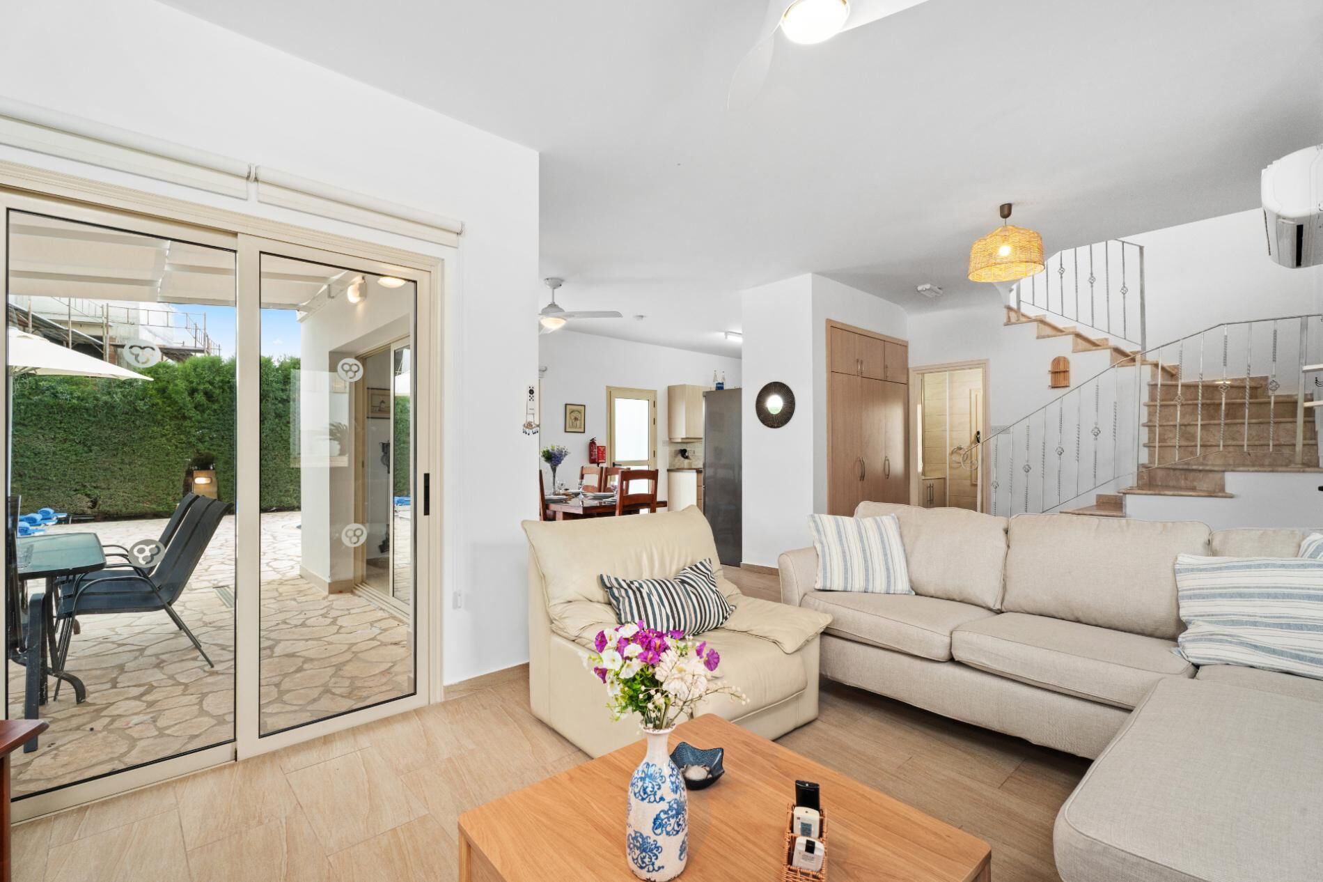 A modern living room with a sofa, coffee table, and a dining area with chairs and a table.