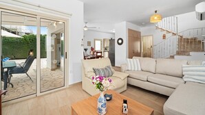 Ein modernes Wohnzimmer mit einer Couch, einem Couchtisch und einem Essbereich mit Stühlen und einem Tisch.