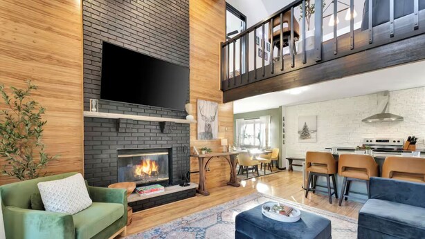 A spacious living area with a fireplace, a dining area, and a kitchen. - 5BR Resort-Style - Game Room, Hot Tub, Fire Pit (East Stroudsburg)