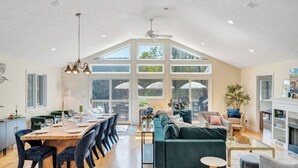 Amplia sala de estar con una mesa de comedor, sillas y un ventanal con vistas a una terraza.