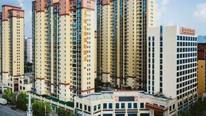 A high-rise hotel with multiple floors, a central entrance, and a parking area. - Vienna 3 Good Hotel Huaran Branch (Xiangxi)