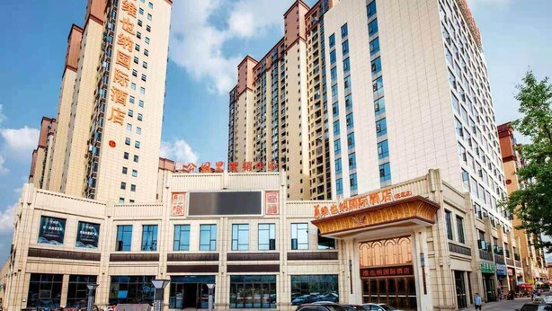 A hotel with multiple floors, a central entrance, and a parking area. - Vienna 3 Good Hotel Huaran Branch (Xiangxi)