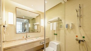 A hotel bathroom with a glass partition, a sink, a toilet, a shower, and a mirror. - Vienna 3 Good Hotel Huaran Branch (Xiangxi)