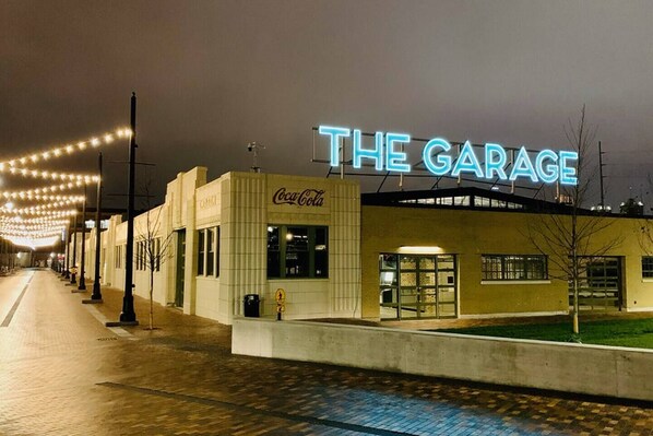 Un bâtiment avec une enseigne au néon indiquant « THE GARAGE » et une enseigne Coca-Cola sur le côté.