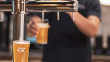 Uma torneira com um copo de cerveja em frente.