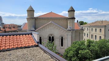 Um edifício com telhado de telhas vermelhas, duas torres e janelas em arco.
