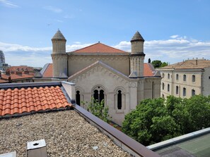 A building with a red-tiled roof, two towers, and arched windows. - Eklo Hotels Montpellier Centre Gare (Montpellier)