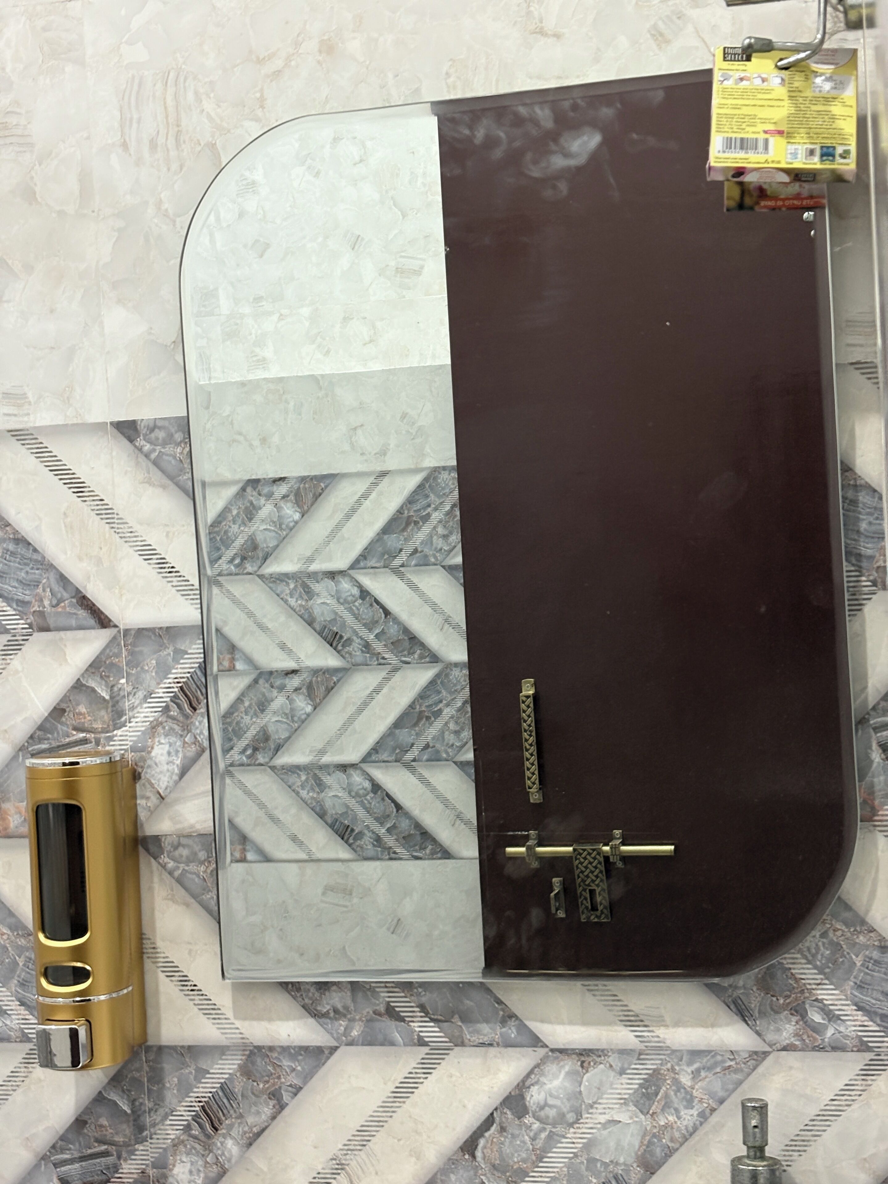 A bathroom with a curved vanity, a gold-colored faucet, and a door with a brass handle.