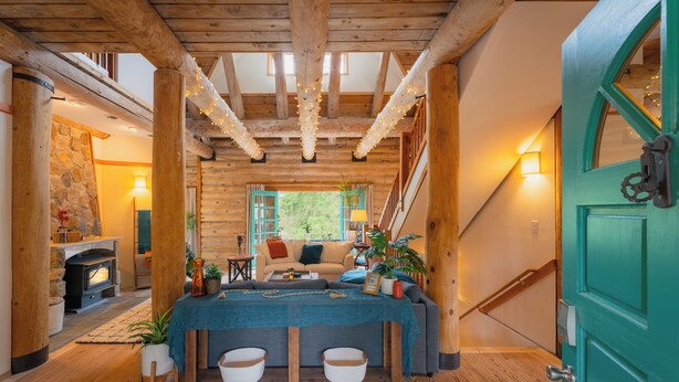 A cozy interior with a wooden ceiling, a dining area with a table, and a staircase. - Blue Roof Lodge - Forest Getaway for Groups (Enumclaw)