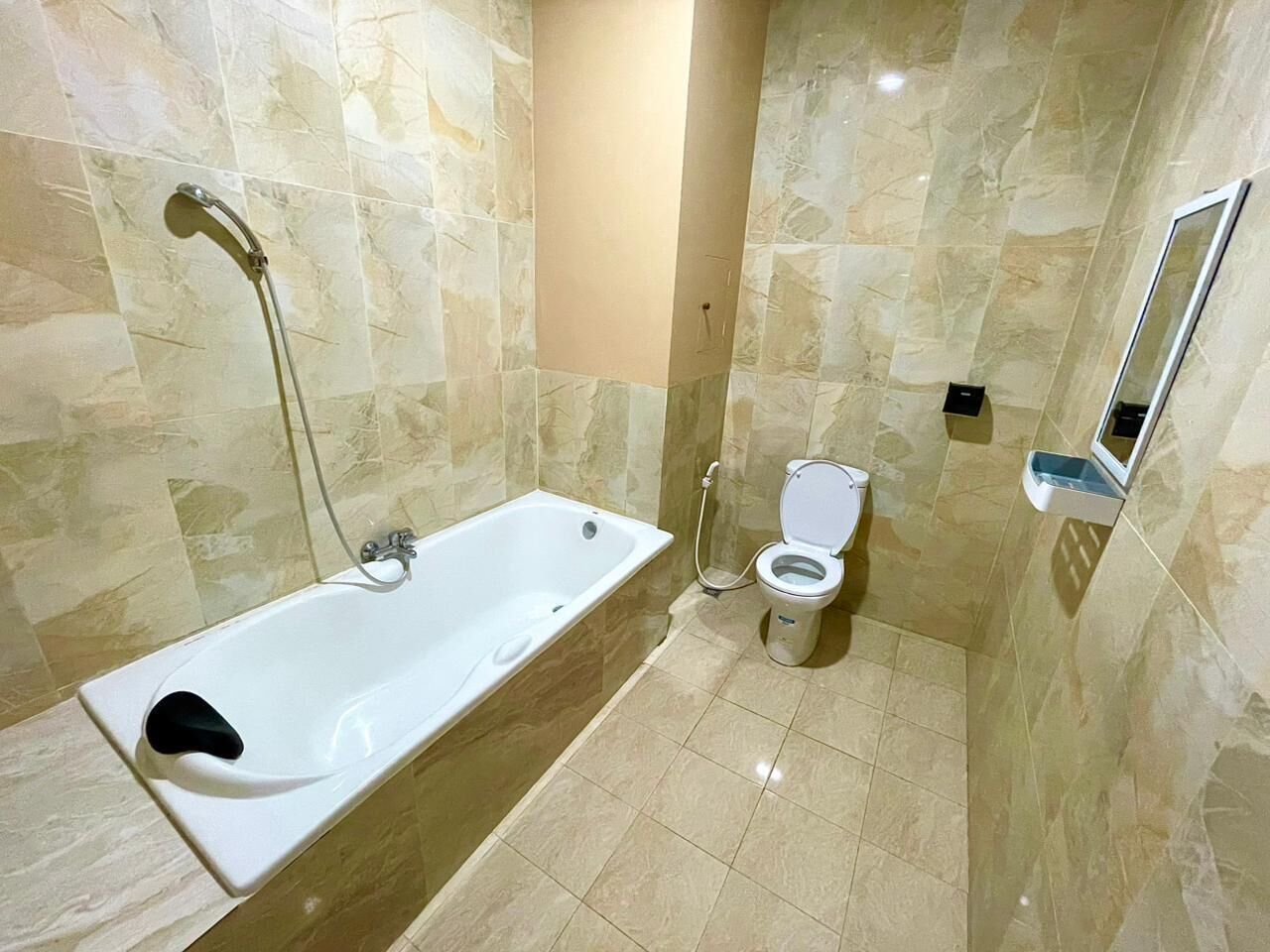 Un baño con bañera, inodoro y espejo.