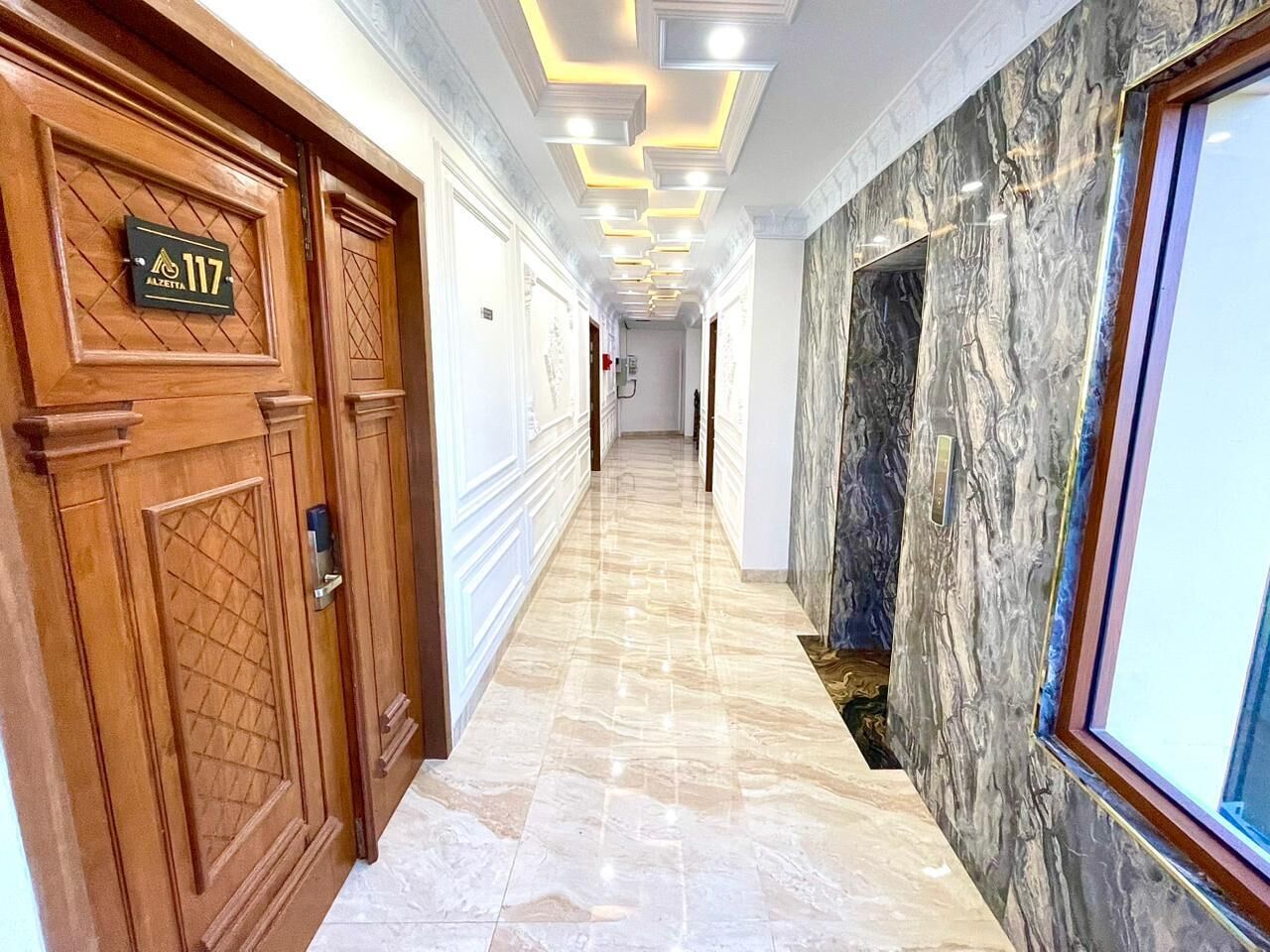 A hallway with wooden doors, a marble floor, and a wall with a marble-like texture.