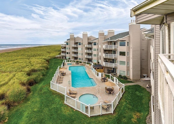 Un hôtel doté d’une piscine, de plusieurs balcons et offrant une vue sur la plage.