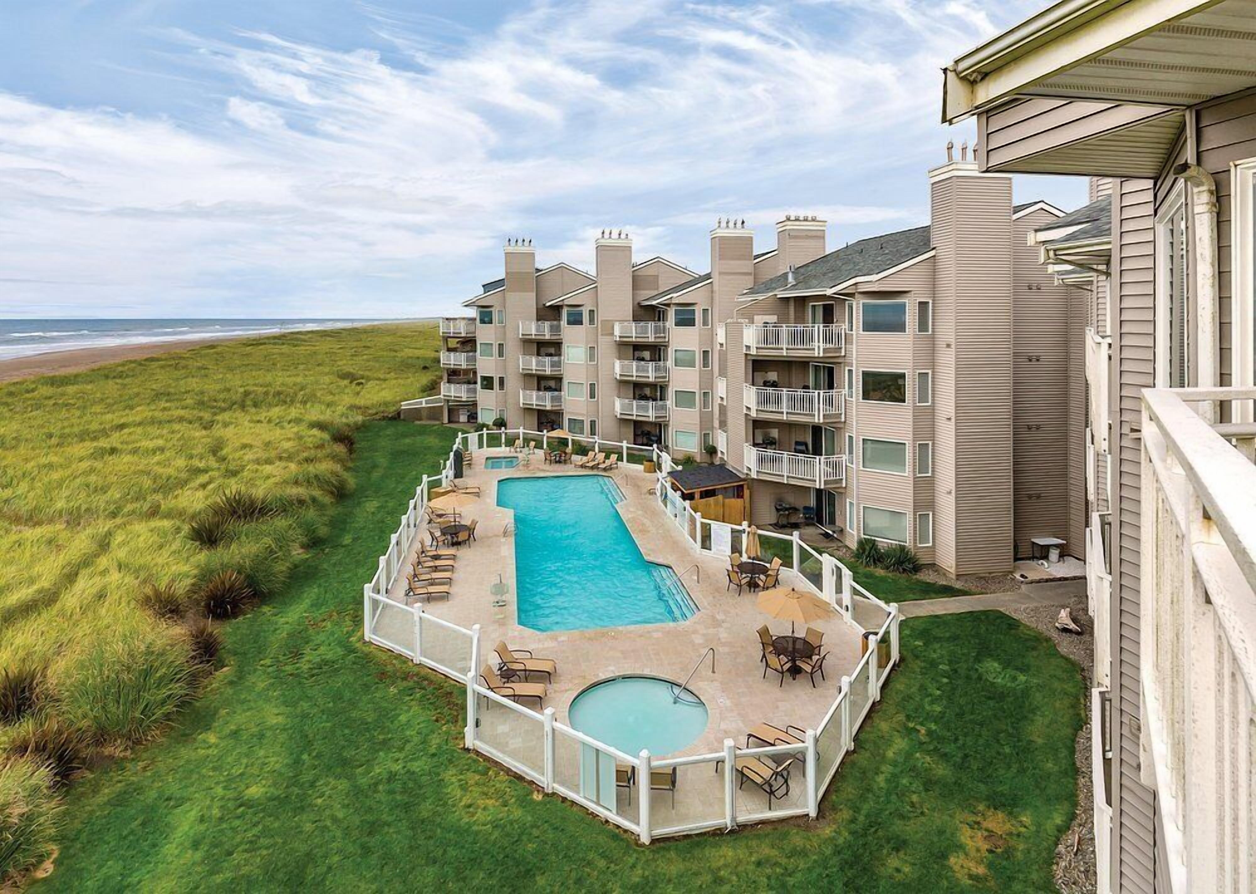 Un hôtel doté d’une piscine, de plusieurs balcons et offrant une vue sur la plage.