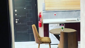 A modern kitchen with a built-in dishwasher, a small round table, and two chairs.