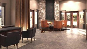 Un interior espacioso con chimenea de piedra, comedor y mostrador de cocina.