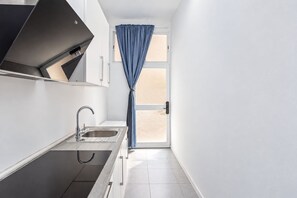 Eine moderne Küche mit Spüle, Schränken und einem Fenster mit Vorhang.