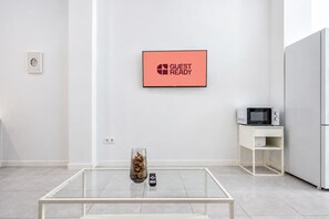 Eine moderne Küche mit Esstisch, Mikrowelle und Kühlschrank.