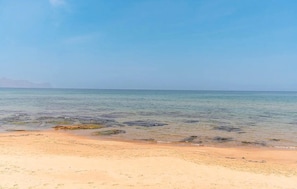Una playa con agua cristalina y una orilla arenosa.