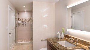 Ein modernes Badezimmer mit Dusche, Toilette und zwei Waschbecken mit Marmorplatte.
