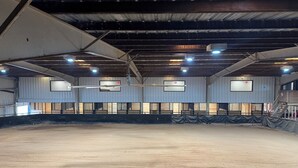 Eine Halle für Sport, mit hoher Decke, Metallträgern und mehreren Lampen.