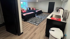 Ein kompaktes Hotelzimmer mit Küchenzeile, einem kleinen Badezimmer und Blick ins Freie.