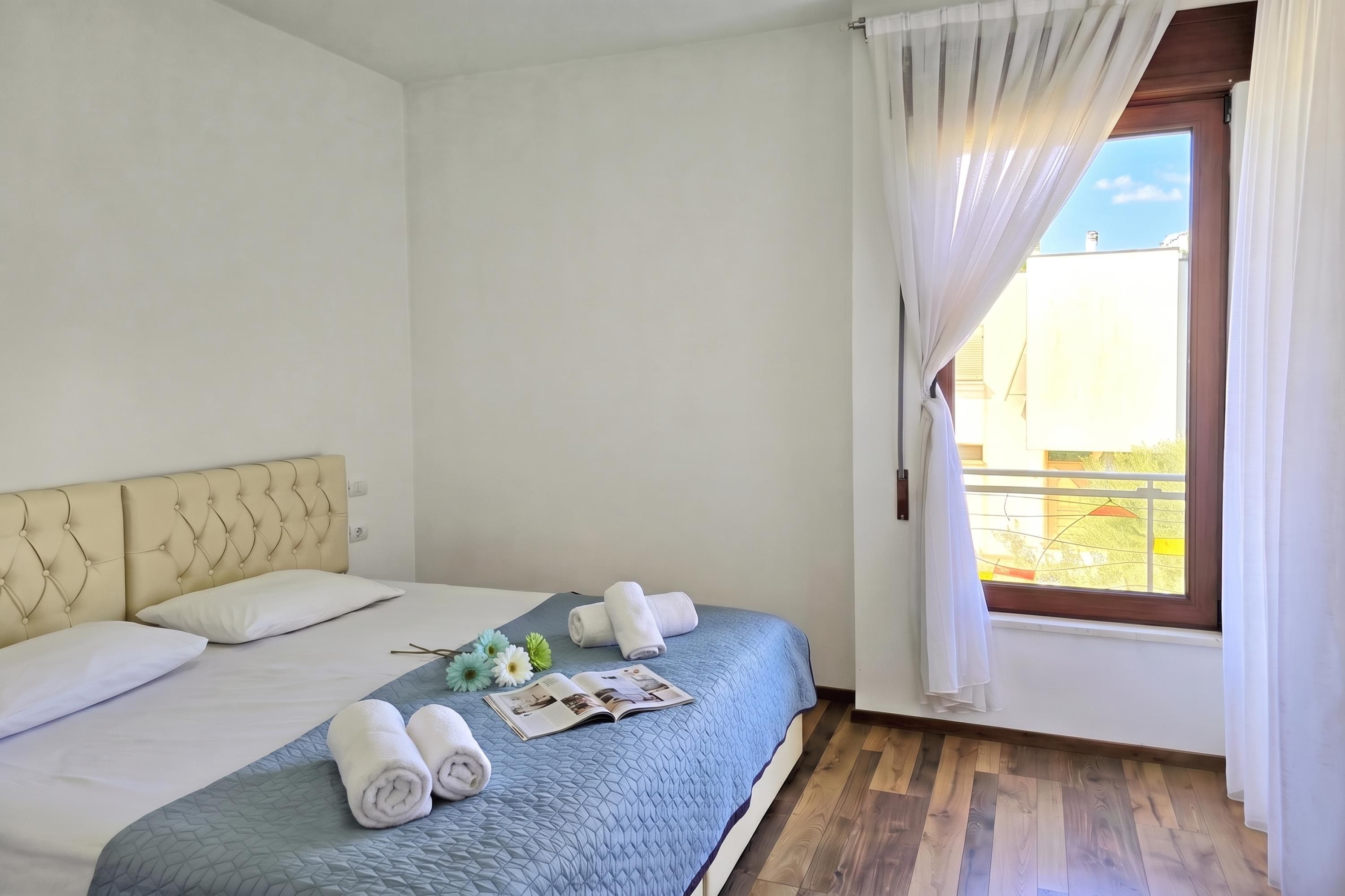 Une chambre d’hôtel avec un lit, une fenêtre avec des rideaux et une vue sur l’extérieur.