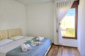 Une chambre d’hôtel avec un lit, une fenêtre avec des rideaux et une vue sur l’extérieur.