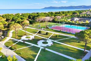 Vue aérienne d’un parc avec un terrain de basketball, des sentiers pédestres et une plage en arrière-plan.