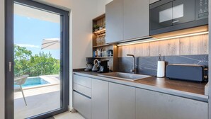 Ett modernt kök med inbyggd mikrovågsugn, kaffebryggare och brödrost.