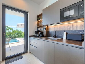 Eine moderne Küche mit integriertem Mikrowellenherd, Kaffeemaschine und Toaster.