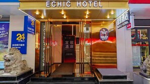Der Eingang zum Echic Hotel mit einer auffälligen Schilder, einer Löwenstatue und einer Treppe zum Eingang.