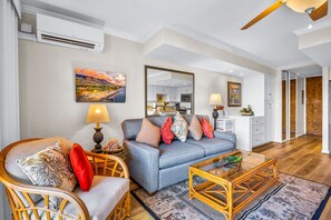 A living room with a sofa, armchairs, a coffee table, and a dining area with a lamp. - Papakea | Ocean View 3 BR, Sleeps 12 | Car Incl. w/ 6+ Nights | PKD ML-3969 by KBM (Lahaina)