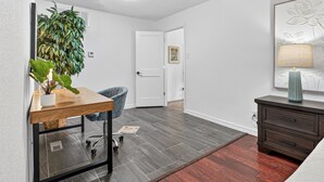 A room with a desk, chair, potted plant, and a dresser. - Beautiful Meandering Way Retreat (Fort Smith)