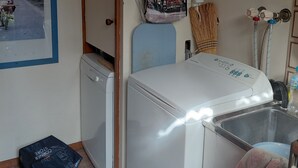 A laundry room with a washing machine, a drying rack, a hat, and a framed picture on the wall. - Close to beaches, shops with Mikbar 50m towards Springs Beach (Point Lonsdale)
