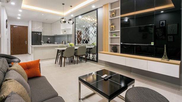 A modern living room with a sofa, a coffee table, and a dining area with chairs and a table. - RiverGate Saigon (Ho Chi Minh City)