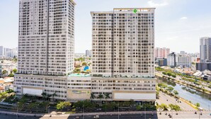 Two high-rise buildings with a river and urban landscape in the background. - RiverGate Saigon (Ho Chi Minh City)