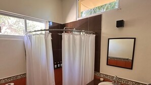 A bathroom with a toilet, sink, shower curtain, and a mirror.