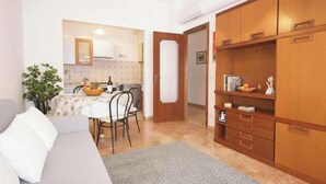 A compact living space with a kitchenette, a dining area, and a seating area with a sofa and chairs. - Holiday apartment mit Klimaanlage und Balkon (Diano Marina)