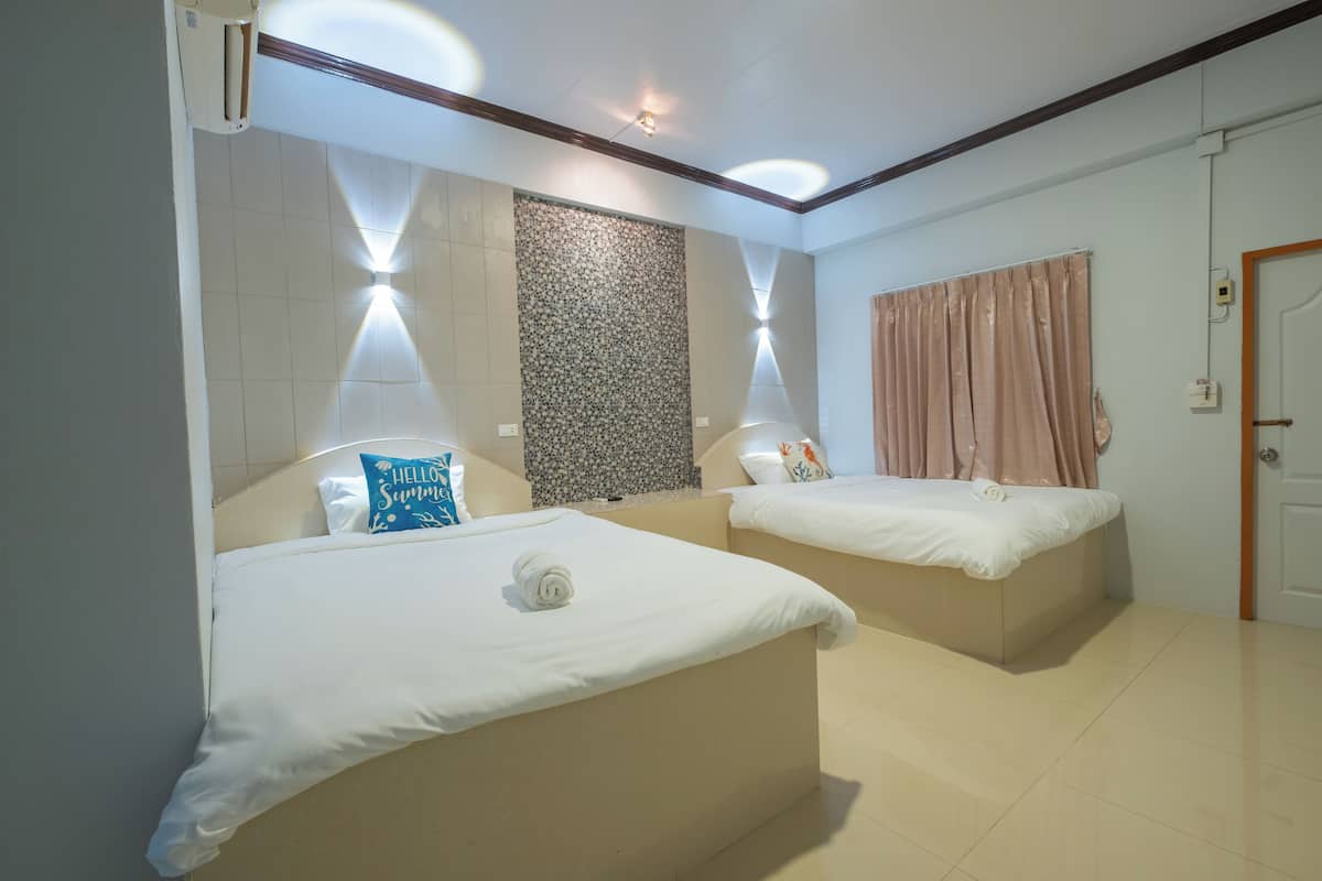 Ein Hotelzimmer mit zwei Betten, einer Wandverzierung und einer Tür.
