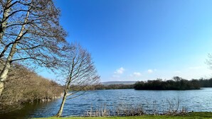 A lake with a grassy foreground and trees on the left. - Wyreside pod, ideal family break on fishing park close to Lancaster and Blackpool (Dolphinholme)